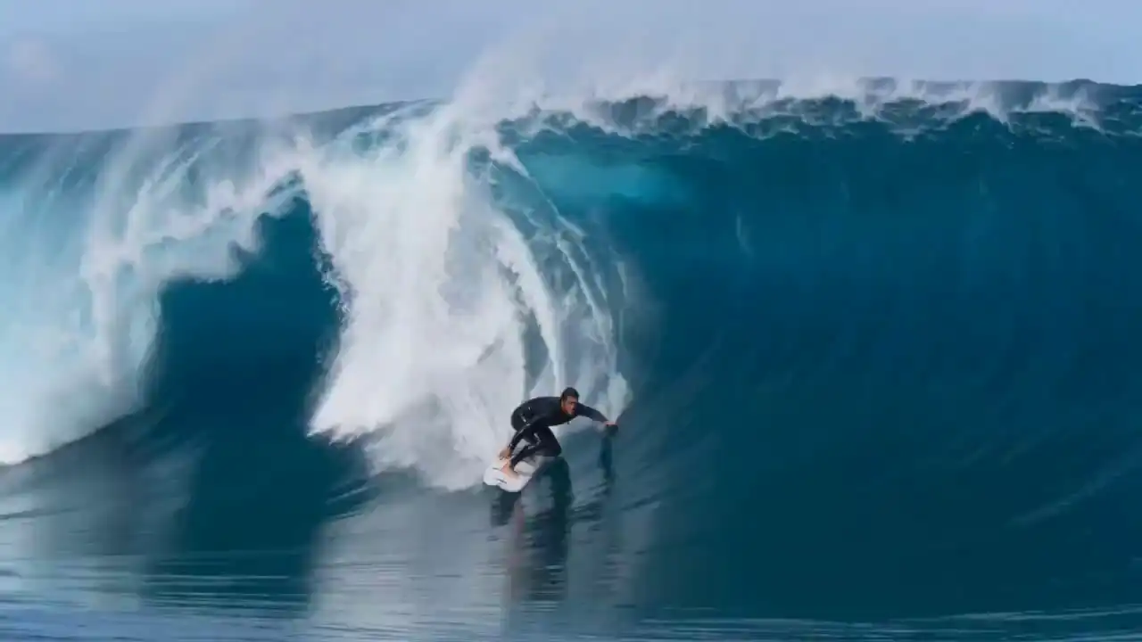 A professional surfer rides through a massive blue wave tunnel in cinematic slow motion, captured by Seedance 2 Mini.
